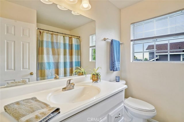 full bath with vanity, toilet, and curtained shower