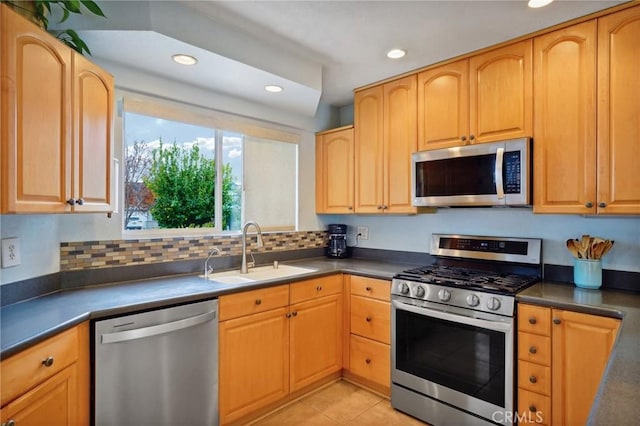 kitchen with a sink, appliances with stainless steel finishes, and dark countertops
