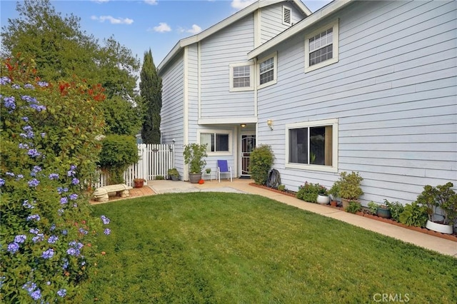 back of house featuring a yard, a patio, and fence