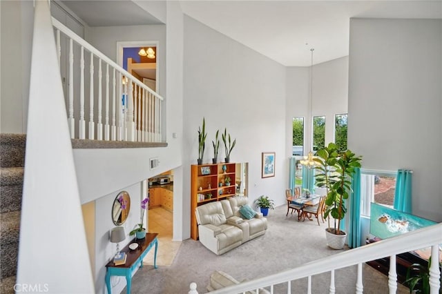 living room featuring visible vents, carpet flooring, stairs, and a high ceiling