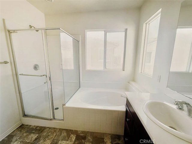 full bath featuring vanity, stone finish flooring, a garden tub, and a shower stall