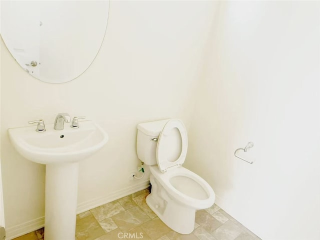 bathroom with toilet, baseboards, and a sink