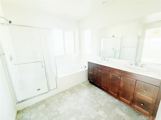 bathroom featuring double vanity, a stall shower, a sink, and a bath
