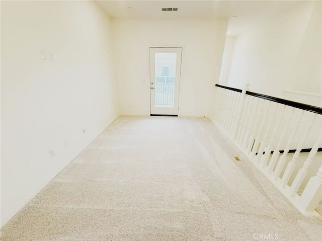 empty room featuring carpet floors and visible vents
