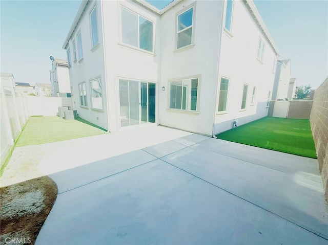 back of house with a fenced backyard, a patio area, and stucco siding