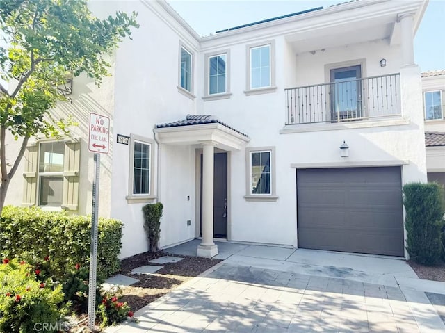 mediterranean / spanish-style home featuring an attached garage, driveway, and stucco siding