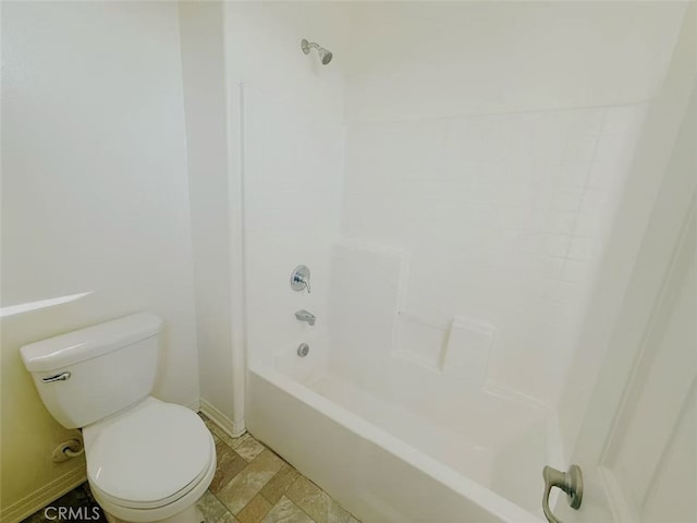 full bath featuring baseboards, washtub / shower combination, and toilet