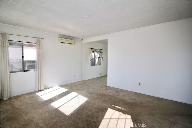 carpeted empty room with a textured ceiling, a wall mounted AC, a healthy amount of sunlight, and cooling unit