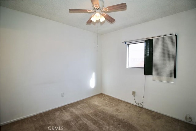 carpeted spare room featuring a textured ceiling and ceiling fan