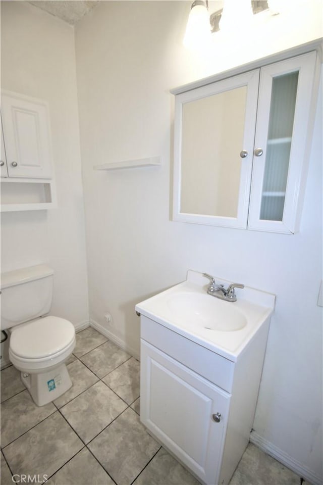 half bath featuring vanity, baseboards, and toilet