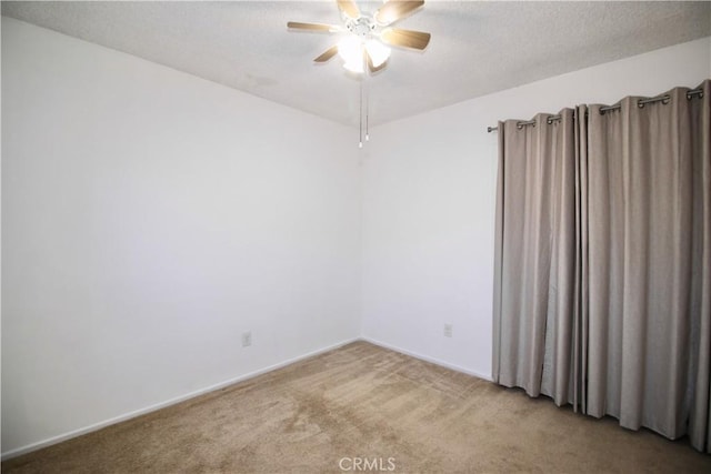 carpeted spare room with baseboards, a ceiling fan, and a textured ceiling