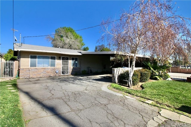 single story home featuring fence, stone siding, stucco siding, a carport, and driveway