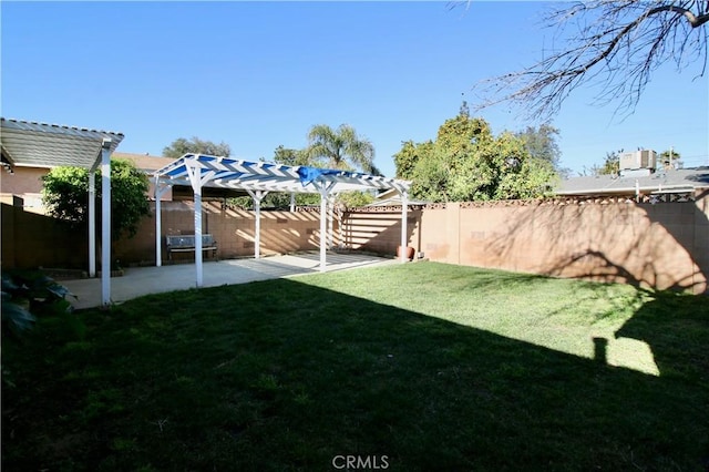 view of yard with a fenced backyard, a pergola, and a patio area