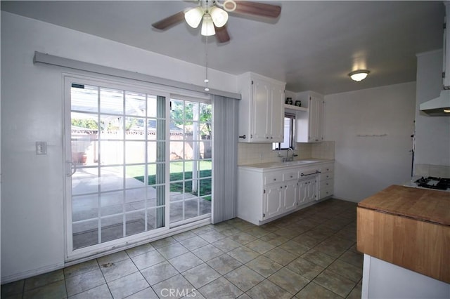 kitchen with ceiling fan, light countertops, white cabinetry, tasteful backsplash, and under cabinet range hood