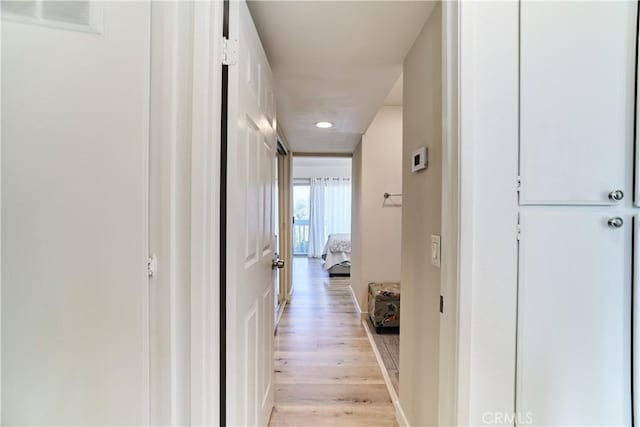hall featuring light wood-type flooring and recessed lighting