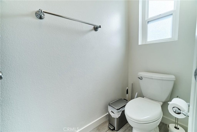 bathroom featuring baseboards, toilet, and wood finished floors