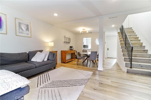 living area with light wood-style floors, recessed lighting, visible vents, and stairway