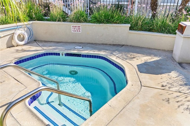 view of pool featuring a patio area, a hot tub, and fence
