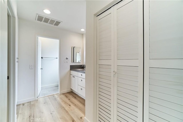 bathroom with visible vents, recessed lighting, wood finished floors, and vanity