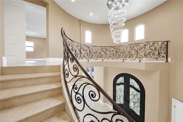 stairway with french doors, recessed lighting, and a chandelier