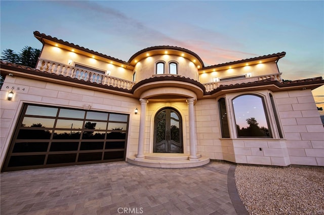 view of front of property featuring decorative driveway and a garage