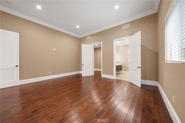 unfurnished bedroom with visible vents, dark wood-style flooring, crown molding, and baseboards