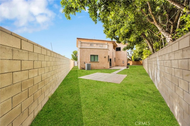 rear view of house with a balcony, a fenced backyard, a patio area, a lawn, and central air condition unit