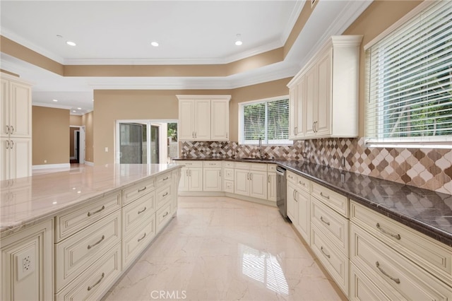 kitchen with crown molding, a sink, dark stone countertops, tasteful backsplash, and stainless steel dishwasher