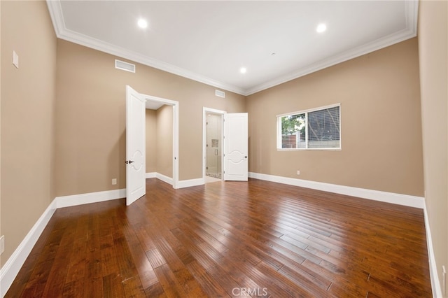 unfurnished room with crown molding, visible vents, and wood finished floors