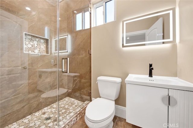 full bath featuring vanity, baseboards, toilet, and a shower stall