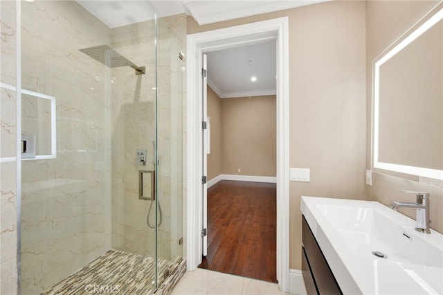 bathroom featuring crown molding, baseboards, a marble finish shower, and vanity