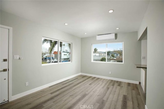 5459 Carlin St, Los Angeles, CA 90016 - spare room with a wall unit AC, recessed lighting, and wood finished floors