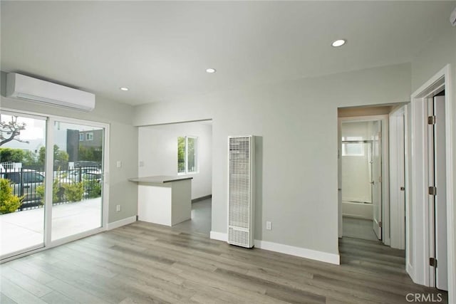 5459 Carlin St, Los Angeles, CA 90016 - unfurnished living room with a heating unit, wood finished floors, baseboards, an AC wall unit, and recessed lighting