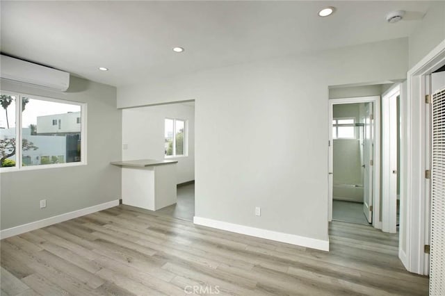 5459 Carlin St, Los Angeles, CA 90016 - unfurnished living room featuring baseboards, a wall mounted AC, recessed lighting, and light wood-style flooring