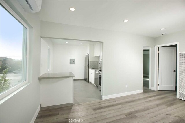 5459 Carlin St, Los Angeles, CA 90016 - kitchen with white cabinets, light wood finished floors, freestanding refrigerator, recessed lighting, and backsplash