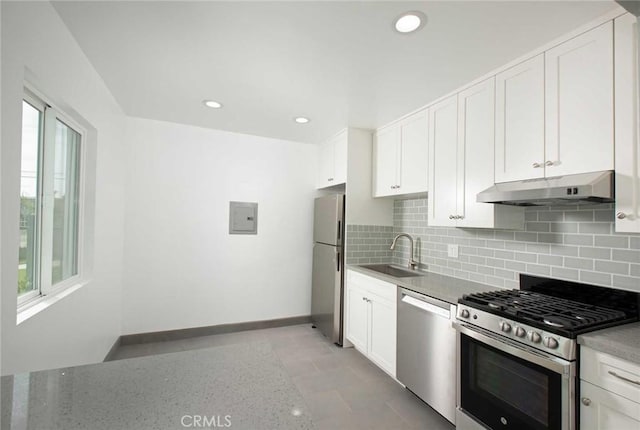 5459 Carlin St, Los Angeles, CA 90016 - kitchen featuring white cabinetry, under cabinet range hood, tasteful backsplash, a sink, and appliances with stainless steel finishes