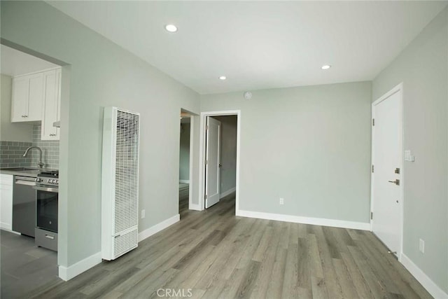 5459 Carlin St, Los Angeles, CA 90016 - unfurnished living room featuring recessed lighting, baseboards, light wood finished floors, and a heating unit