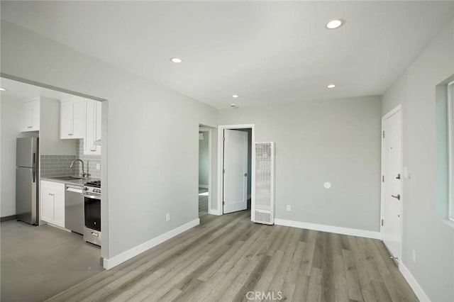 5459 Carlin St, Los Angeles, CA 90016 - unfurnished living room with a sink, light wood finished floors, a heating unit, recessed lighting, and baseboards