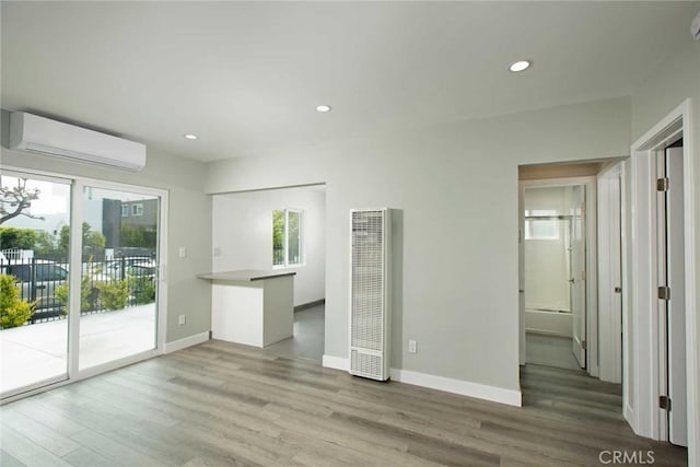 5459 Carlin St, Los Angeles, CA 90016 - unfurnished living room featuring a wall mounted AC, wood finished floors, baseboards, recessed lighting, and a heating unit