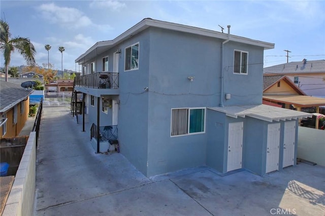 5459 Carlin St, Los Angeles, CA 90016 - exterior space with a patio, stucco siding, stairway, and a balcony