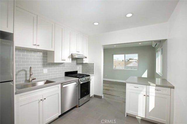 5459 Carlin St, Los Angeles, CA 90016 - kitchen featuring backsplash, appliances with stainless steel finishes, a sink, under cabinet range hood, and white cabinetry