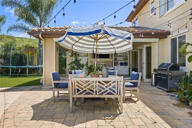 view of patio / terrace featuring outdoor dining area, a trampoline, and a grill