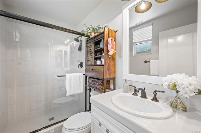 bathroom featuring vanity, a stall shower, toilet, and visible vents