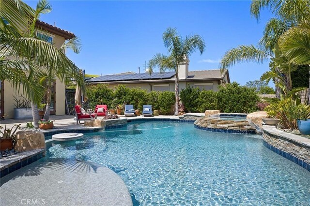 pool featuring an in ground hot tub and a patio area