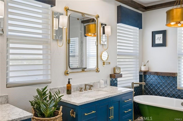 full bath with a soaking tub, tile walls, a wealth of natural light, and vanity