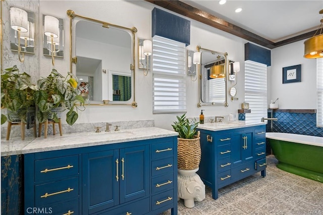 full bathroom with a sink, two vanities, and a soaking tub