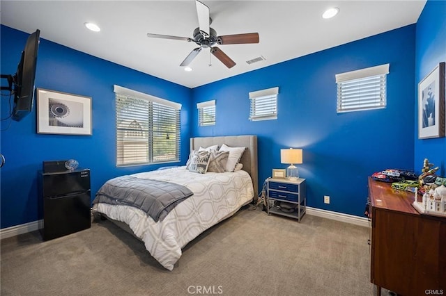 bedroom with multiple windows, visible vents, carpet floors, baseboards, and freestanding refrigerator