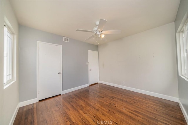 unfurnished bedroom with visible vents, a ceiling fan, baseboards, and wood finished floors