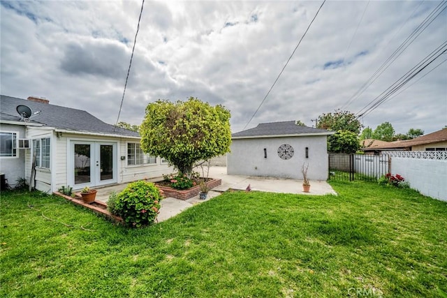 back of house with a lawn, a fenced backyard, a patio area, and french doors