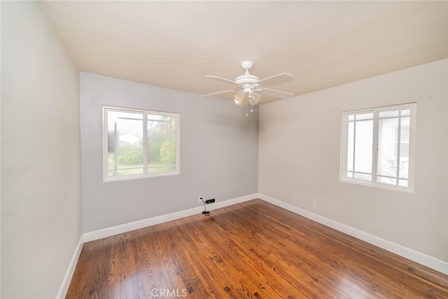 empty room with baseboards, ceiling fan, and wood finished floors